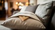 © Hamster - Decorative beige cushion with small carved wooden frame peeking out on a sofa, cozy home interior decor, residential comfort concept.