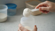 © Jim - Measuring scoop with baby milk powder over bottle. Concept of infant formula preparation and safe feeding. Measuring scoop with baby milk powder over bottle. Concept of infant formula preparation and