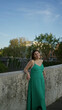 © Krakenimages.com - Woman in a green dress leaning on a stone bridge wall on a street in rome by a lamppost beside the river at dusk; serenity travel.