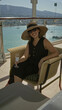 © Krakenimages.com - Woman holding wineglass and smiling, wearing wide brim hat and sunglasses while seated in wicker chair on cruise terrace with sea view; relaxation vacation.