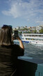 © Krakenimages.com - Woman brunette holding smartphone taking photo of ferry and city skyline on street in istanbul; travel memory serenity.