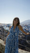 © Krakenimages.com - Woman smiling and leaning on a railing at a building viewpoint in santorini, greek island; travel vacation serenity.