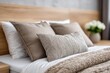 © whitestorm - Cozy bedroom interior with comfortable bed and pillows, featuring a wooden headboard and a soft, textured throw blanket, decorated with a vase of white flowers.