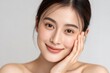 © whitestorm - A beautiful young Asian woman with flawless skin, showcasing natural beauty and skincare routine, posing with a gentle smile and soft touch.