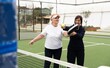 © Angelov - a girl teaches her grandmother how to play padel