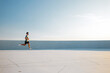 © muse studio - Runner trains on a bright day in an open space with a blue sky and a minimal background