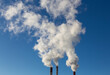 © Dmitry Presnyakov - CHP emissions. Smoking chimney releasing smoke against a blue sky. Smoke from factory pipe of heat station in the city. Air pollution. Nuclear power plant cooling. CO2, greenhouse gases emissions.