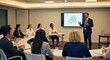 © UnPhouvith - A confident man is presenting a business strategy to a group of diverse professionals in a modern conference room. He stands before a large screen displaying a graphic of gears.
