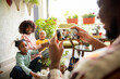 © Marko Geber - Family gardening on home balcony while parent takes photo