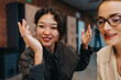 © qunica.com - Two colleagues in business attire smile and gesture while chatting in a modern office. A friendly moment captures collaboration and positive energy in a professional setting.