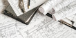 © shintartanya - Architecture blueprints with rolled plans, compass and clipboard on desk, construction documentation and engineering design workflow,planning and project management concept, copy space.