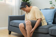 © KMPZZZ - Muscle pain or leg pain, suffer asian aged woman, senior massaging brawn leg calf muscle cramps or spasm, older trauma from inflammation of tendon at calves while sitting on sofa. Health care concept.
