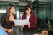 © Stock 4 You - Mature businesswoman investor holding financial sale invoice or enterprise law document, discussing with consult colleague marketing project looking on paper. Female workers working as team in office