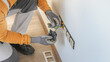 © Sabrewolf - Electrical installation. An electrician's hands during installation a wall sockets to multi pack socket.