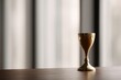 © KASUEMA SALAE - Realistic photography of a single golden trophy sitting on a high-end wooden desk in a blurred office, soft focus, success concept