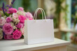 © Smejanka - Blank white paper gift bag on a table with pink flowers
