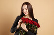 © New Africa - Woman with bouquet of red roses on beige background