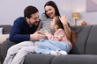 © New Africa - Pregnant woman, her husband and daughter on sofa at home