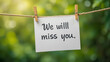 © Jessica - Message We will miss you written on white paper, hung with clothespins on rope. Concept of farewell, leaving, good bye note. Blurred green nature background. Love message, farewell concept.