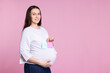 © New Africa - Choosing name for baby. Pregnant woman holding notes with words Boy and Girl on pink background, space for text