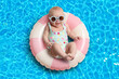 © New Africa - Cute little baby with sunglasses on inflatable ring in swimming pool, above view