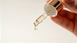 © RND - First person perspective holding beauty serum bottle with liquid dropper, clean aesthetic cosmetic product photography.