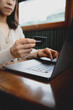 © Ton Photographer4289 - Woman holding a credit card while using a laptop for online shopping at cafe. Conceptual image representing e-commerce, digital payment.