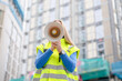 © Iryna - Construction worker gives instructions in a busy area with buildings under construction