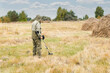 © Светлана Акифьева - Man with electronic metal detector device working on outdoors.
