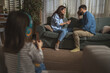 © Miljan Živković - Parents arguing at home with child wearing headphones