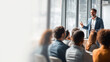 © Anchanar S - Business consultant leads workshop, engaging diverse group of professionals in modern office setting. atmosphere is collaborative and focused, with natural light streaming through large windows