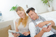 © auremar - Couple on sofa, using tablet and smartphone