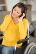 © auremar - a woman wheelchair wearing headphones