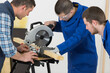 © auremar - carpenter teaching apprentice how to use circular saw