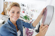 © auremar - woman putting up new clock in her home