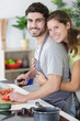 © auremar - portrait of a cheerful young couple cooking together