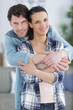 © auremar - couple hugging in the living room of their new house