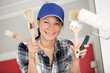 © auremar - smiling girl holding paint roll and brushes