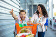 © auremar - happy couple having fun while going to the supermarket