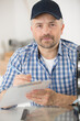 © auremar - portrait of a smiling repairman standing with his clipboard