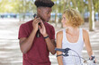 © auremar - couple with bicycle conferring as man speaks on smartphone