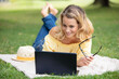 © auremar - young woman using laptop in the park