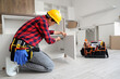 © Pixel-Shot - Male worker installing cabinet door in kitchen
