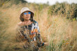 © chokniti - Woman traveler wearing colorful patterned sweater and hat standing in golden grass field under warm sunlight enjoying nature, outdoor adventure, and peaceful autumn atmosphere at countryside