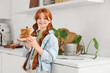 © Pixel-Shot - Teenage redhead girl holding toasts with nut butter in kitchen
