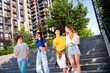 © deagreez - Lively group of young people enjoying a sunny day outdoors in a modern cityscape with casual style and joy