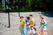 © deagreez - Group of happy young students enjoying a sunny day together outdoors near campus stairs