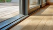 © Pixelzone - Stunning photo of close-up of a modern low-profile sliding glass door threshold track on a light oak wood floor leading to a terrace.