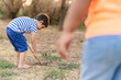 © Jordi Mora - Boy exploring ground with stick barefoot outdoors