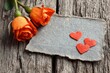 © Julia - On rustic wood, a red heart, orange roses, and an empty note for a love or romance message